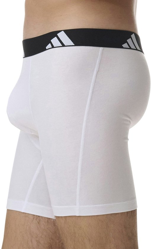 Wit boxerhort met zwarte band met witte Adidas logo's, vanaf de zijkant gezien, gedragen door een model.