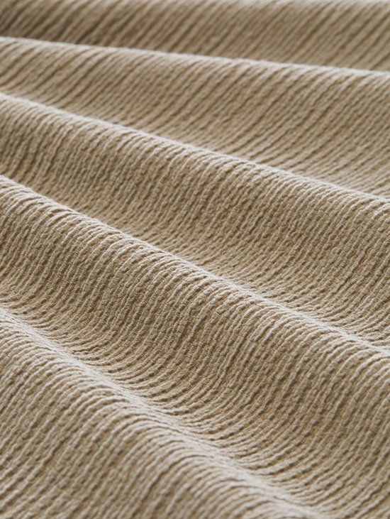 Detail van de stof van de olijfwitte culottebroek met structuur.