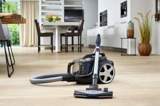 Philips PowerPro Expert stofzuiger met slang en mondstuk in een woonkamer.
