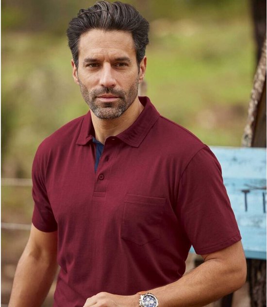 Man met bordeauxrode poloshirt met korte mouwen, borstzakje en donkerblauwe kraag.