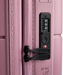 Detail van een roze American Tourister koffer met TSA-slot en ritssluiting.