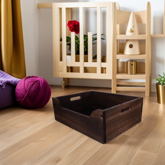 Donkerhouten krat in een kamer met een paarse bol wol en houten meubel op de achtergrond.
