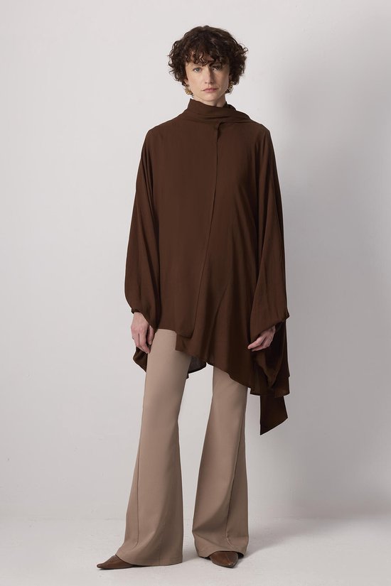 Model draagt een donkerbruine, soepelvallende kimono met een opstaande kraag en wijde mouwen, gecombineerd met beige broek.