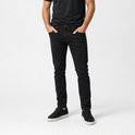 Man in een zwarte T-shirt en zwarte slim fit broek, handen in de zakken.