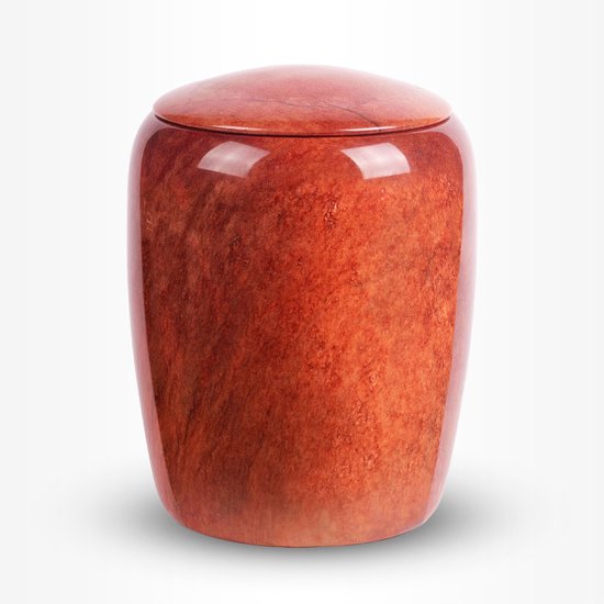Crematie urn van natuursteen, oranje-rood met een gepolijste, houten nerf textuur en een ronde deksel.