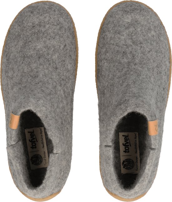 Grijze wollen pantoffels met leren label en bruine zool, van bovenaf gezien.
