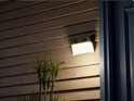 Zwarte en witte wandlamp met camera, verlicht een houten muur.