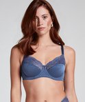 Blauwe bh met stippenpatroon, kanten bovenrand en strikje, gedragen door een model.