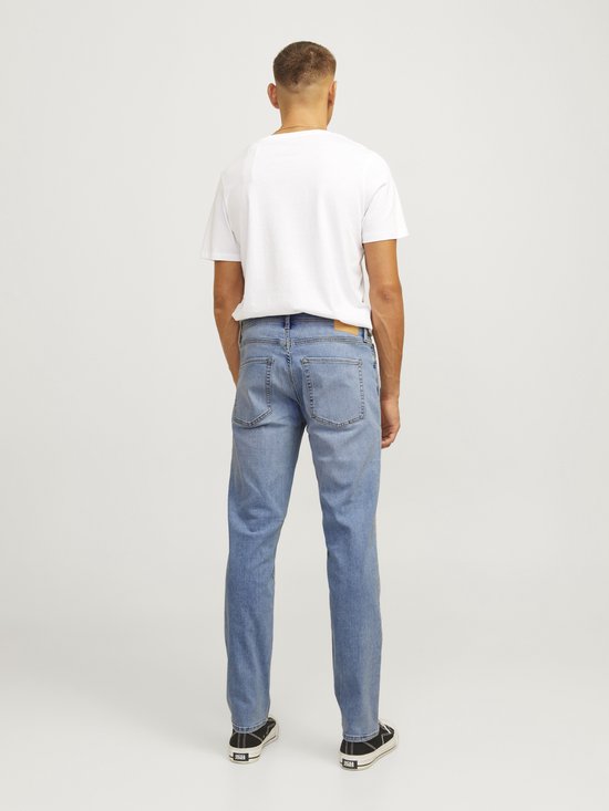 Man met rug naar de camera in lichtblauwe jeans.