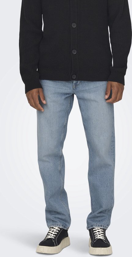 Man draagt een zwarte gebreide cardigan en lichtblauwe jeans met een effen been.