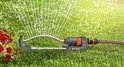 Zwenksproeier van Gardena met oranje details, sproeit water op gras.