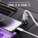 Een donkergrijze Buddi autolader met twee poorten, aangesloten op twee smartphones via USB-A en USB-C kabels in een auto-interieur.