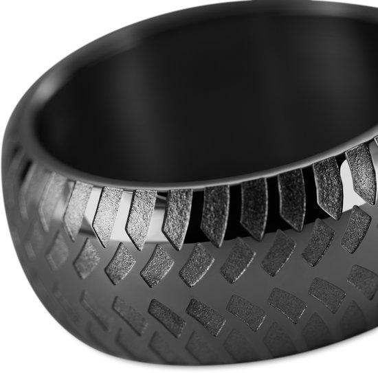 Close-up van een zwarte ring met een gedetailleerd, geometrisch patroon aan de zijkant.