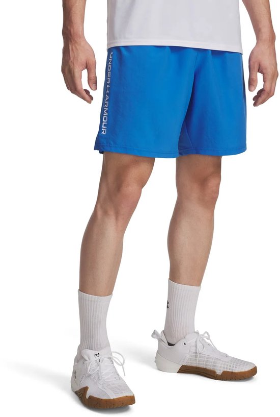 Man in een blauwe Under Armour sportbroek met 'UNDER ARMOUR' logo op de zijkant.