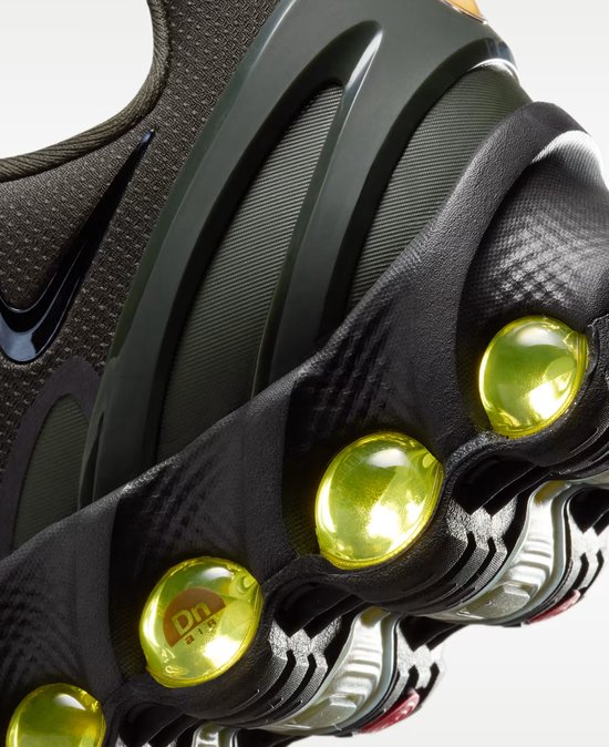 Close-up van de zool van een donkergroene Nike Air Max sneaker met gele luchtkussens.