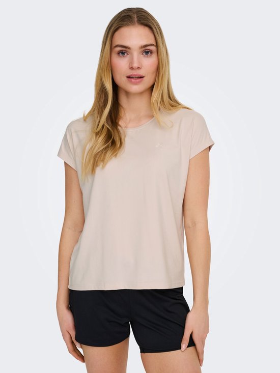 Model in beige sportshirt met korte mouwen en logo op linkerborst, met zwarte short.
