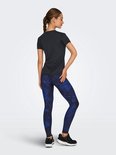 Model draagt zwart t-shirt, achterkant, met korte mouwen en ronde hals. Gecombineerd met blauw-zwarte legging.
