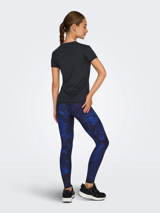 Model draagt zwart t-shirt, achterkant, met korte mouwen en ronde hals. Gecombineerd met blauw-zwarte legging.
