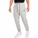 Man in een grijze Nike joggingbroek met een zwarte ritszak op de zijkant.