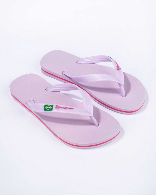 Lichtpaarse Ipanema slippers met rode accenten op de zoolrand en Braziliaanse vlag op de bandjes.