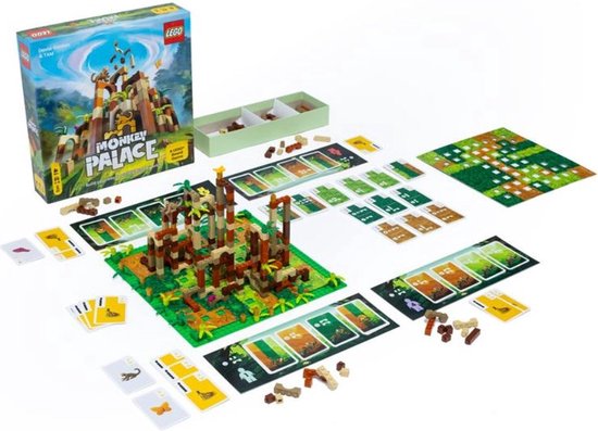 Een LEGO Monkey Palace bordspel opstelling met een doos, een bruine, oranje en beige toren, kaarten en groene speelmat.