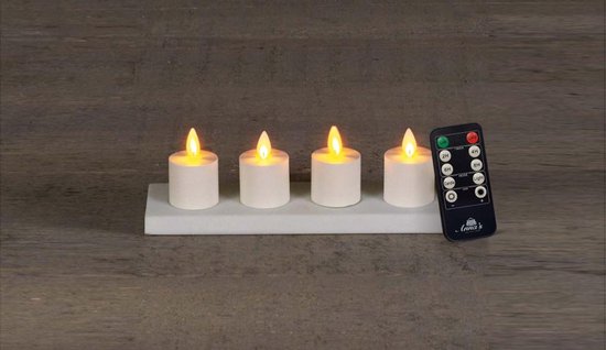 Vier witte LED-theelichtjes op een wit plateau met een afstandsbediening ernaast.