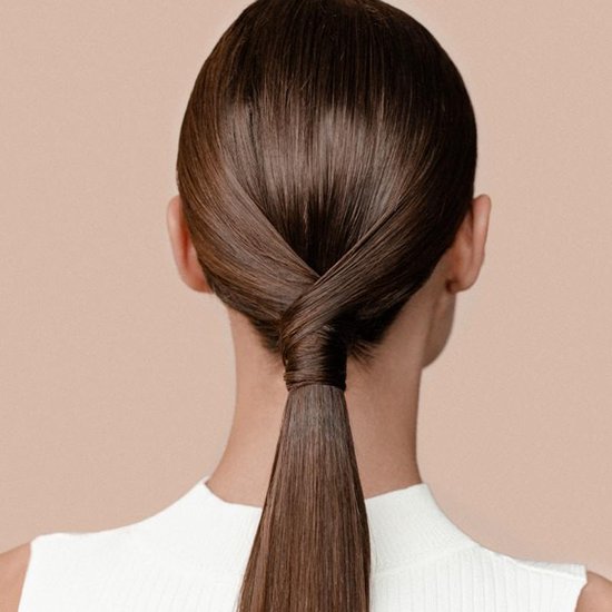Arrière d'une femme aux cheveux longs, bruns et lisses, en queue de cheval serrée avec une torsion.