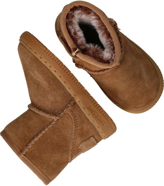 Twee bruine suède laarsjes, een met rits en witte fluffy voering, de ander in profiel, met SHOESME op de zool.