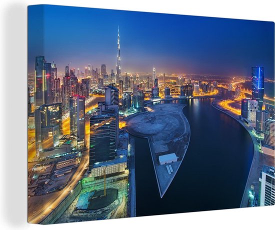 Canvas Schilderij Dubai als een schitterende lichtgevende stad in de nacht - 120x80 cm - Wanddecoratie