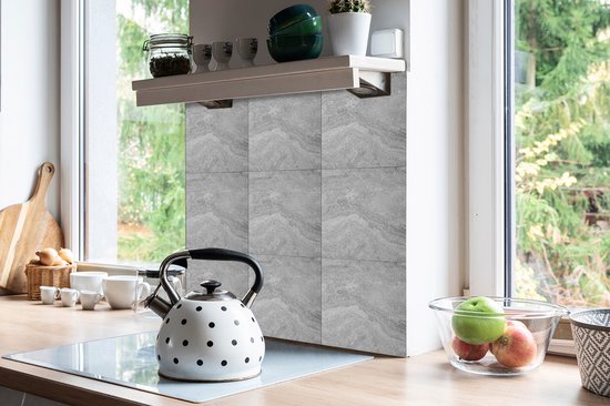 Keuken met grijze, zelfklevende vinyltegels met marmerlook achter de kookplaat.