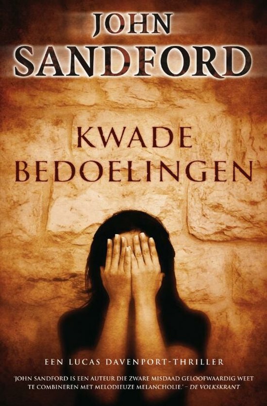 Boekcover met de titel "Kwade Bedoelingen" van John Sandford. Een persoon bedekt het gezicht met handen voor een stenen muur.