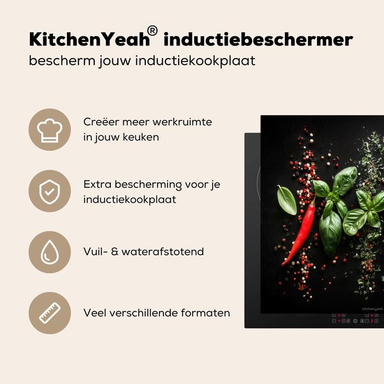Zwarte inductiebeschermer met basilicum, rode pepers en peperkorrels.