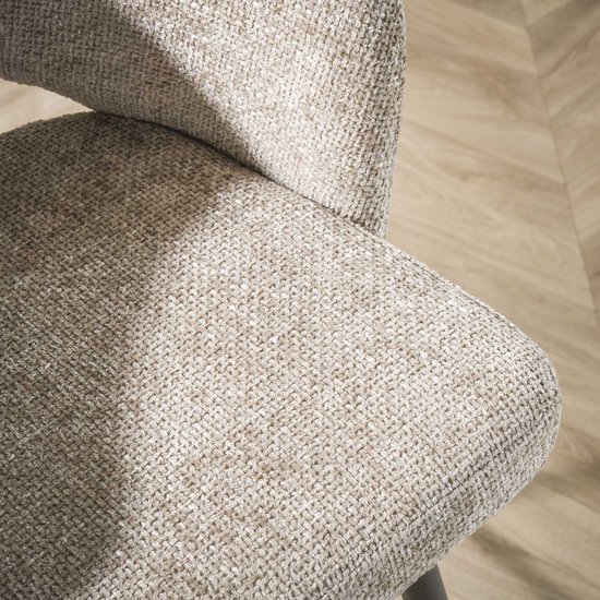 Detail van de beige textuur van de zitting en rugleuning van een eetkamerstoel.