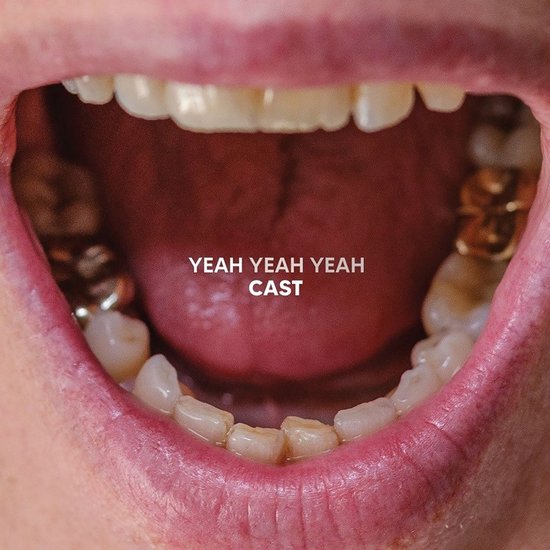 Open mond met tanden en gouden kiezen. Tekst: YEAH YEAH YEAH CAST.