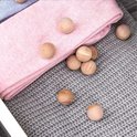 Houten cederballen op roze en grijze gebreide stoffen.