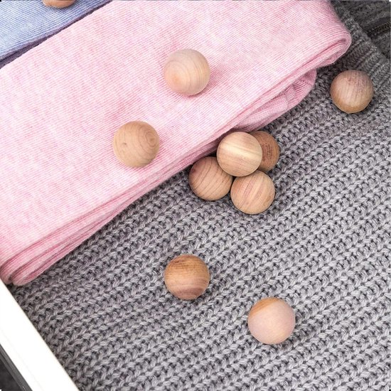 Houten cederballen op roze en grijze gebreide stoffen.