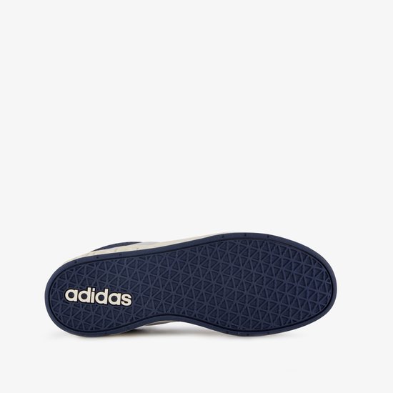 Zool van een donkerblauwe Adidas sneaker met een beige zool en een driehoekig patroon.