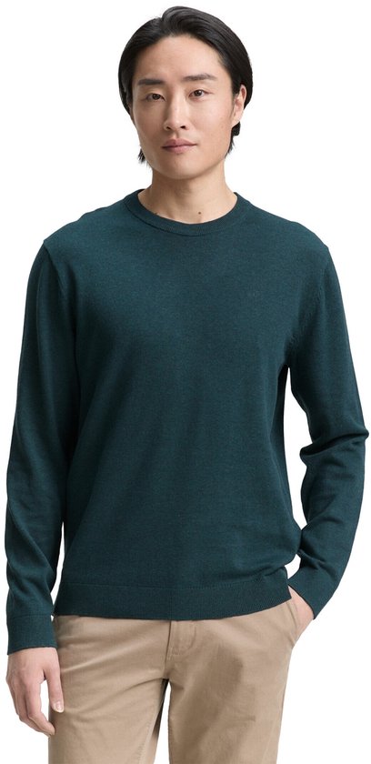 Man in donkergroene trui en beige chino.