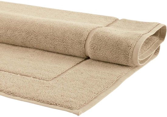 Opgerolde beige badmat, getoond op een grijze achtergrond. De zachte badstof textuur is goed zichtbaar.