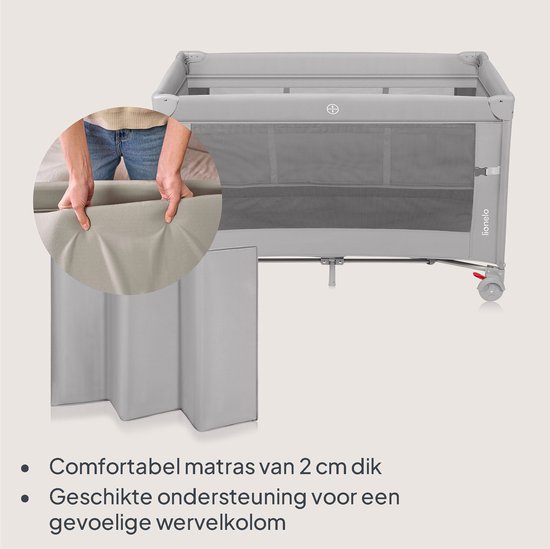 Grijs reisbedje met gaas, matras en een vrouw die de matras vasthoudt.