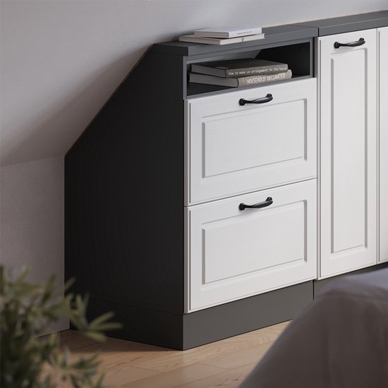 Witte ladefronten met zwarte handgrepen op een antracietkleurige schuine kast.