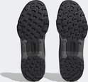 Onderkant van twee zwarte lage wandelschoenen met een grof profiel en het 'Traxion'-logo.