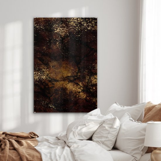 Abstract glas-in-lood schilderij in bruin en zwart met gouden spikkels, hangend boven een bed.