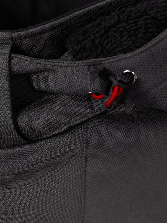 Detail van het verstelbare capuchonkoord met rode accenten op een grijze softshell jas.