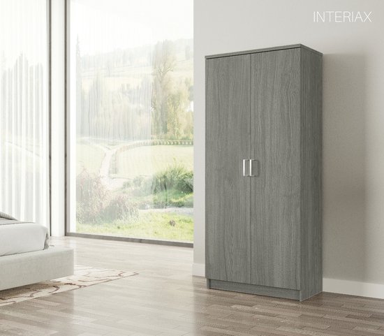 Grijze kledingkast met twee deuren en zilverkleurige handgrepen, in slaapkamer.