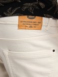 Detail van het leren label op een beige korte broek.