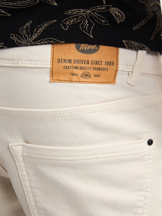 Detail van het leren label op een beige korte broek.