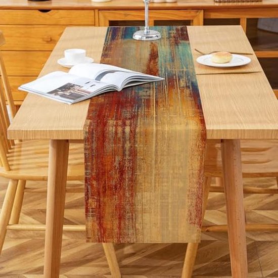 Chemin de table avec des rayures rouges, oranges et bleues sur une table en bois.