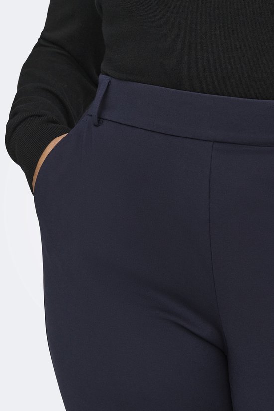 Detail van de donkerblauwe broek met insteekzakken.