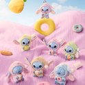 Zeven Stitch pluche speelgoedjes in slaapmutsjes, zittend op roze, pluizige heuvels met snacks en donuts.